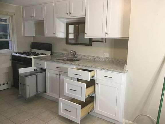Convenient pull out trash and recycle, granite countertop with stainless steel sink.