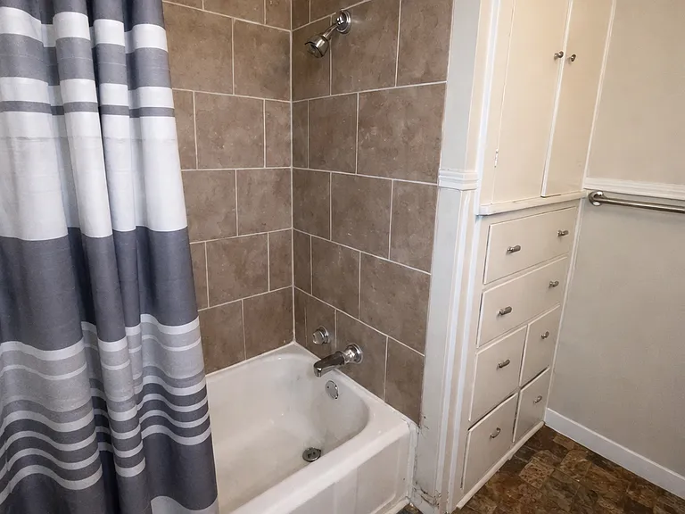 Upstairs full bath with tiled shower/tub and extra cabinets for storage
