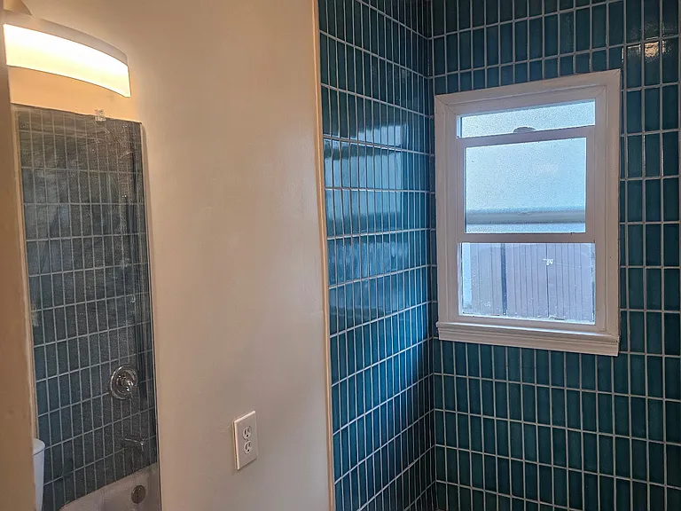 Newly refreshed bathroom with premium bath surround tile and next fixtures