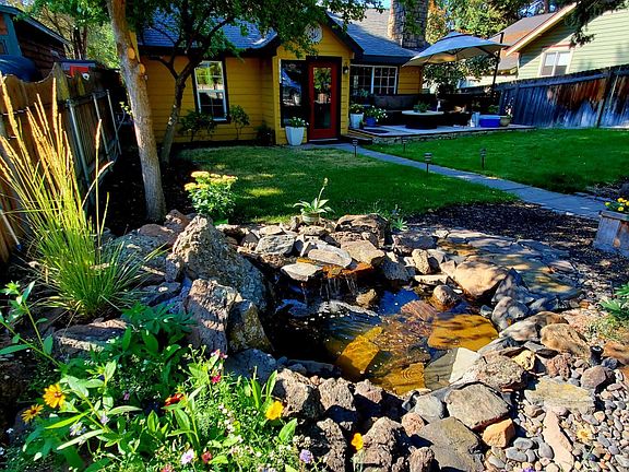 Fenced yard with beautiful water feature / pond.