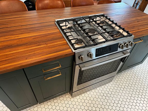 Kitchen island and stove. Drawer trash bin