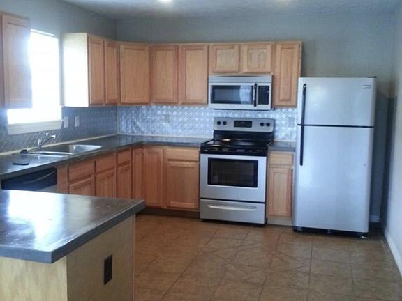 Large kitchen with concrete counters, tin backsplash, stainl