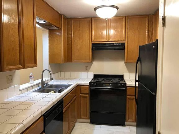 Kitchen with new tile floors, electric range/Oven, Refrigerator, Dishwasher & cabinets.
