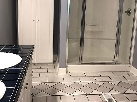 Master Bathroom with large glass-enclosed shower and linen closet