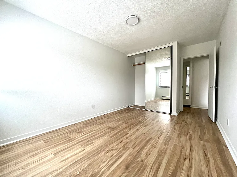 Bedroom with two tone lights, and tall closet with floor to ceiling mirrors.