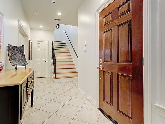 The 2-story foyer with custom light fixture greets visitors upon entry and creates an inviting an open space. The wide staircase is a great feature of the home.