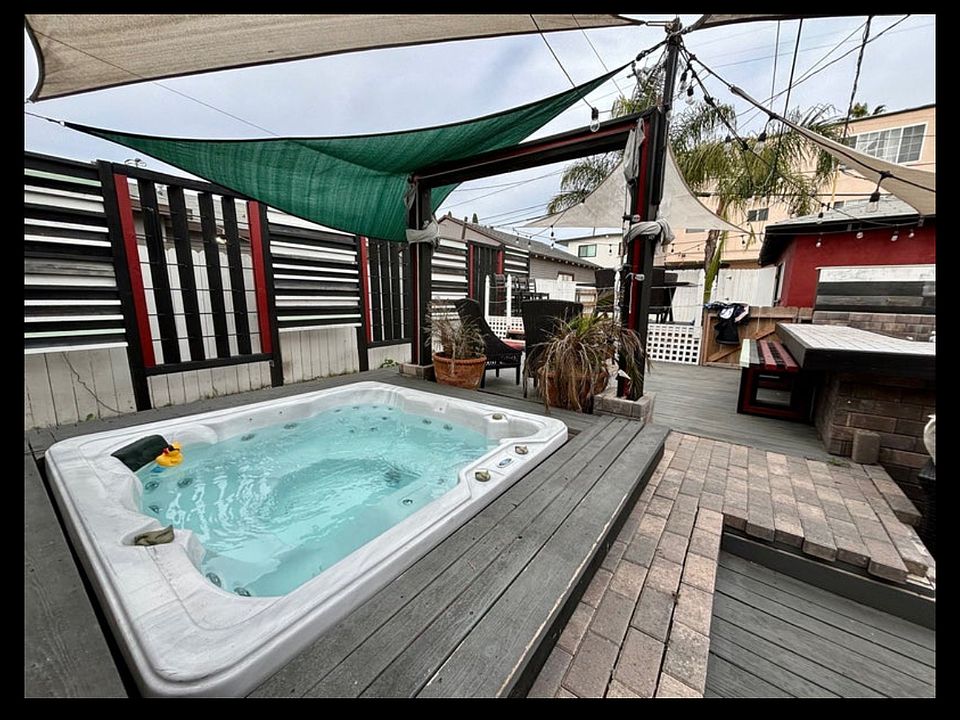 Multilevel deck with hot tub, fire pit, outdoor kitchen, garden and hammock