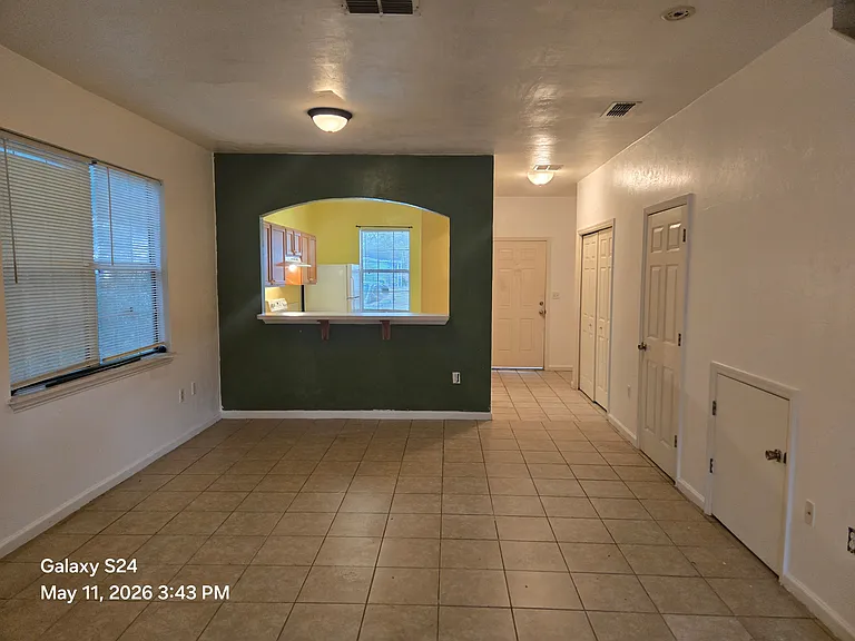 Living Room showing entrance and Kitchen. The side has half bathroom, washer/dryer hookup and the cost closet.