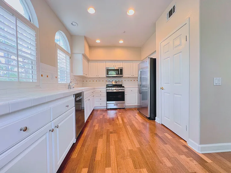 Full stainless steel kitchen with: dishwasher, gas range, microwave, and fridge.