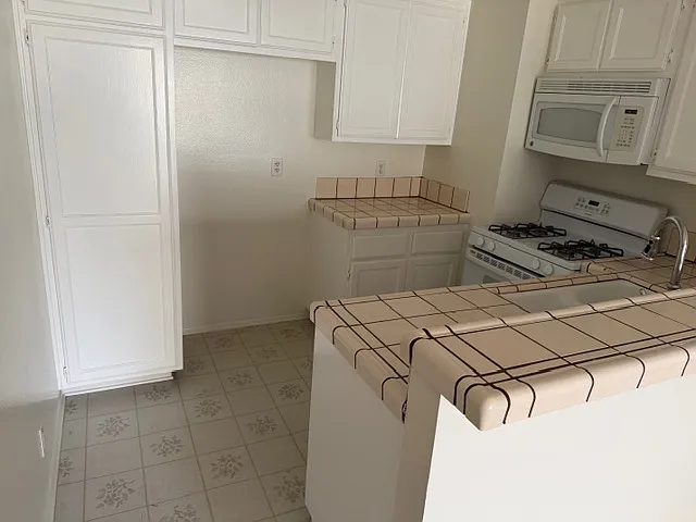 Kitchen Free built-in Microwave, Free standing range/oven, Dishwasher and Garbage Disposal. The color of tile is a vanilla color. Photo does not reflect the correct color