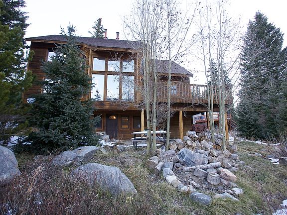 Looking at the back patio area from our private meadow; entrance door to this unit is viewable in the photo.