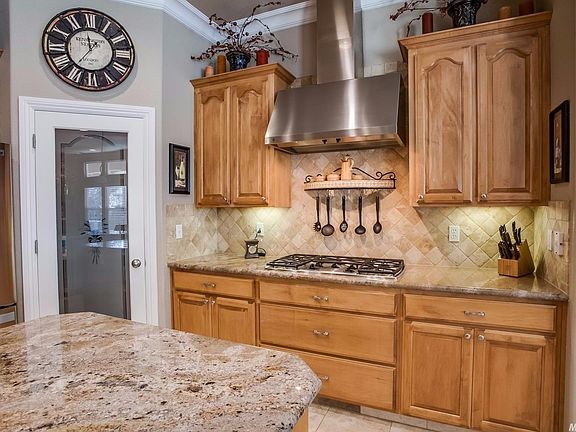 Beautiful maple cabinetry with upgraded hardware, crown molding and travertine flooring are all part of the dramatic kitchen.