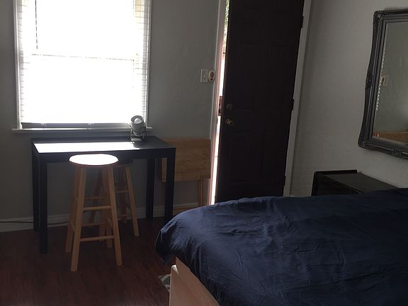 Queen size bed, large mirror and window. Entrance to room.