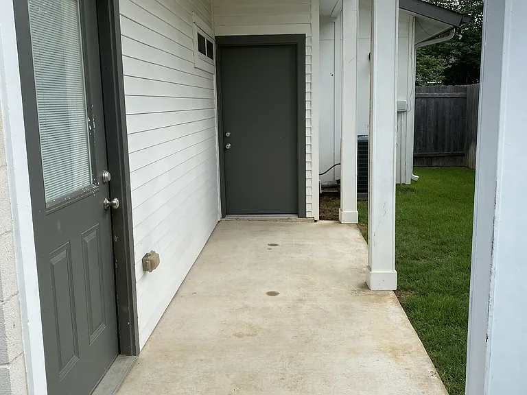Covered back patio off primary bedroom with access to garage