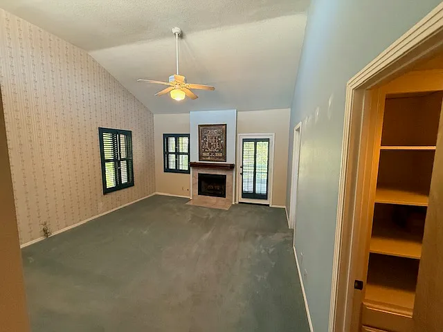 Entering the primary bedroom with lofted ceiling and gas fireplace