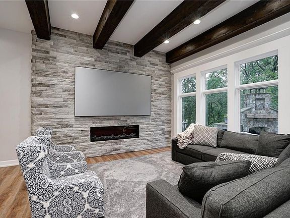 Family room has striking beams and room for ample seating to relax or entertain.