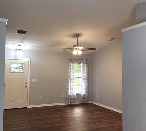 The picture is taken from the dining room showing the living room and front door.