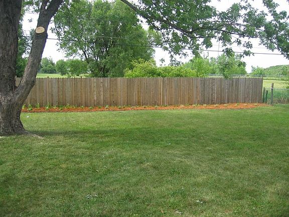 Large, shaded, partially-fenced back yard.