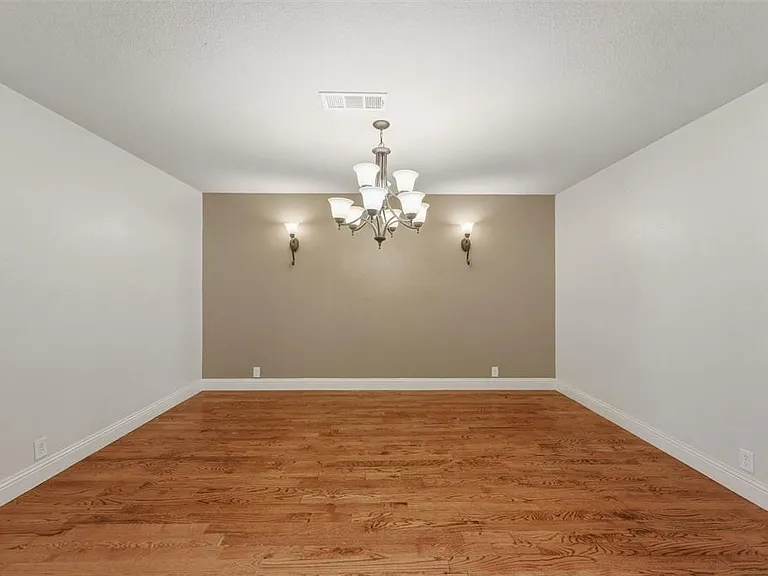 Dining room with light wood finished floors and suspended lighting, hardwood flooring.