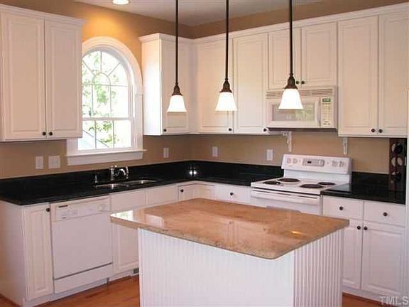 Kitch. features white raised-panel cabinets, granite, lge island, & pantry.