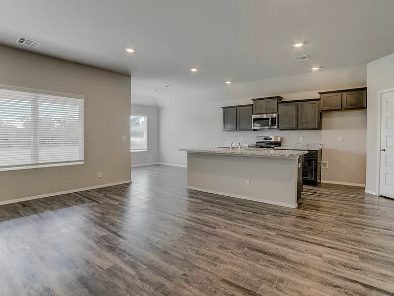 Not pictured is the included refrigerator. Door to the walk-in pantry and open door to the laundry area. Window to the backyard.