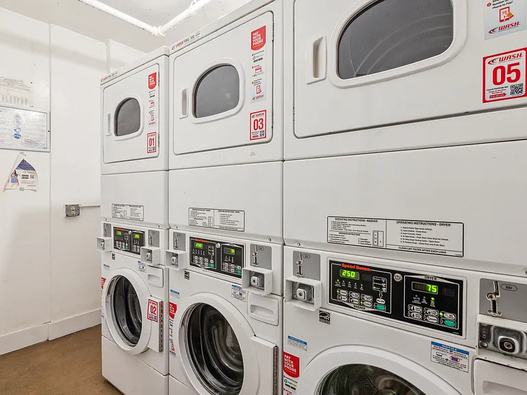 Laundry room with washing machines neatly arranged on a wooden floor