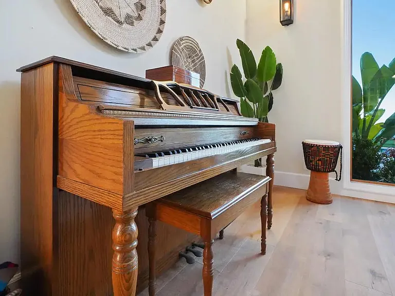 A wooden piano adds a touch of elegance to the space.