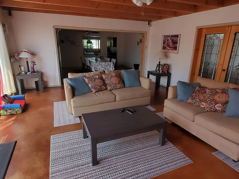 Living Room Looking to Dining Room and Kitchen beyond. Patio door on left and entry to Master Suite on right