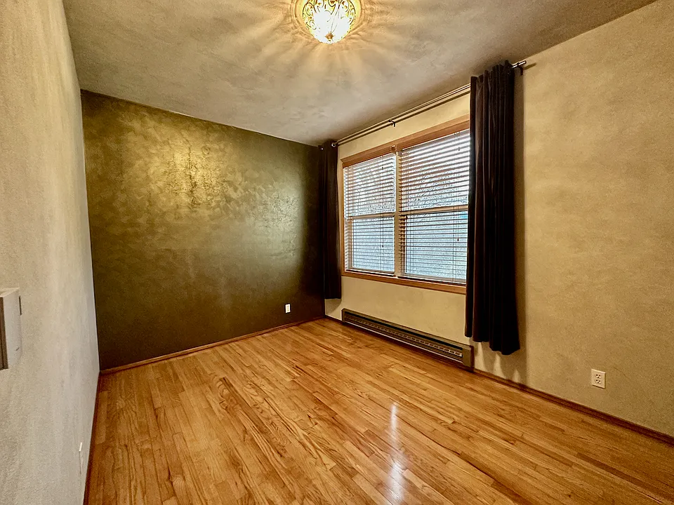 Bedroom. Oak floor. Cotton velvet drapes and wood blinds come with the apartment. Baseboard heater.
