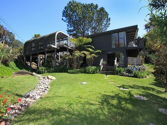 Large grassy side yard with fruit trees