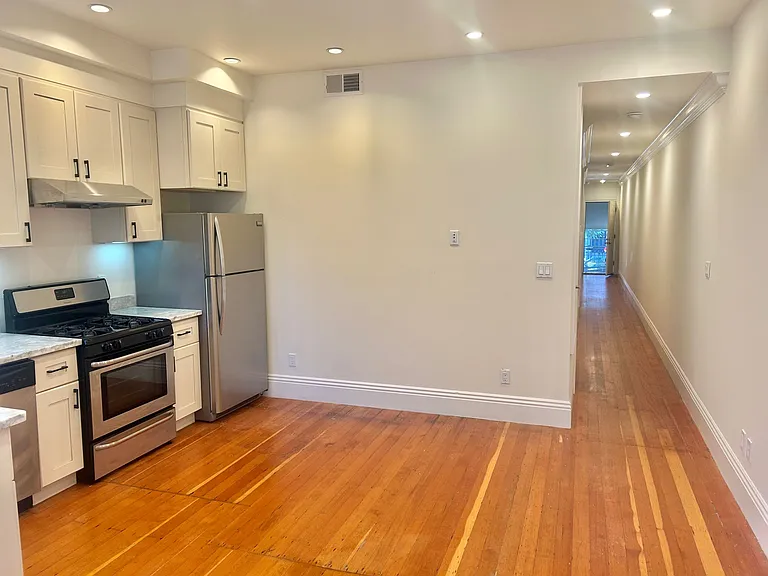 kitchen, looking down hallway to front door. bedrooms and bathroom are to the left, off of this hallway