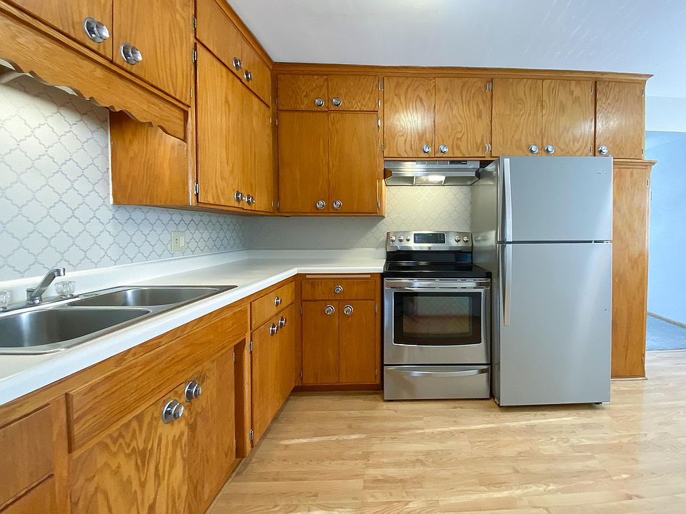 Enjoy cooking in this spacious kitchen with new stainless appliances, a custom backsplash, and ample cabinet space.