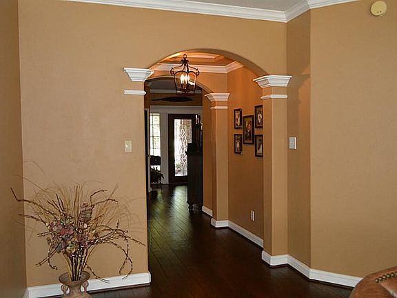 Welcoming Entry w/Leaded  Glass Front Door, Arches, Crown Moulding! Honey, Have you noticed the Gleaming Hand Scraped Wood Flooring? Wow!
