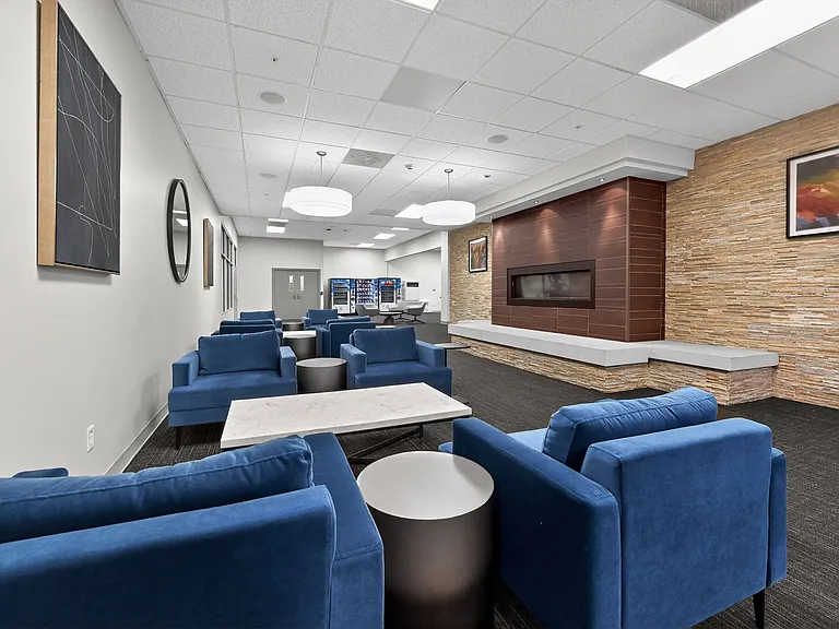 Elegant lounge featuring modern blue seating, stylish decor, and warm wood paneling, perfect for relaxation and socializing.