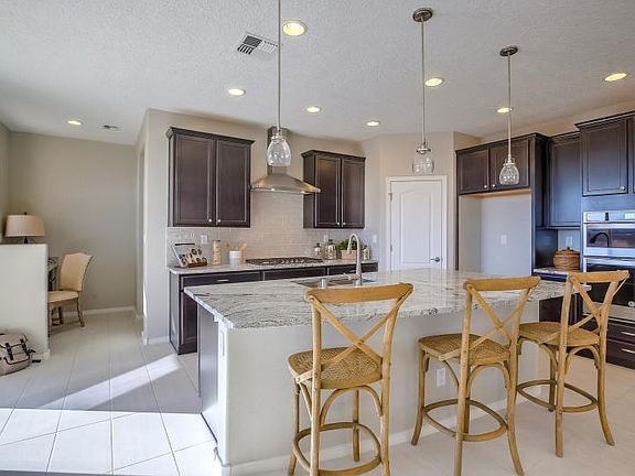 The gorgeous kitchen island with granite counter tops is great for enjoying quick meals and cooking delicious meals.