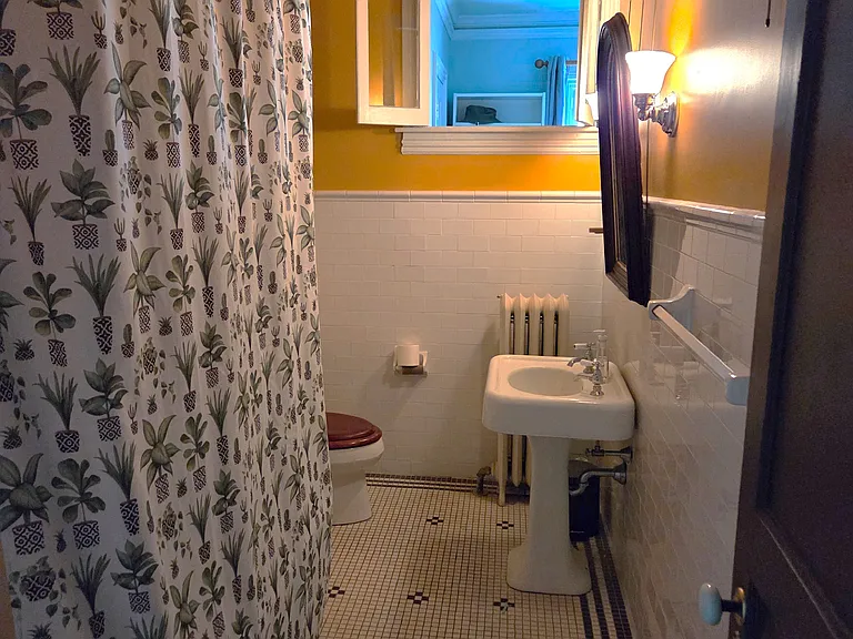 large bathroom with claw tub/shower combo, Kohler toilet, vintage pedestal sink, subway wall tile, and tile flooring