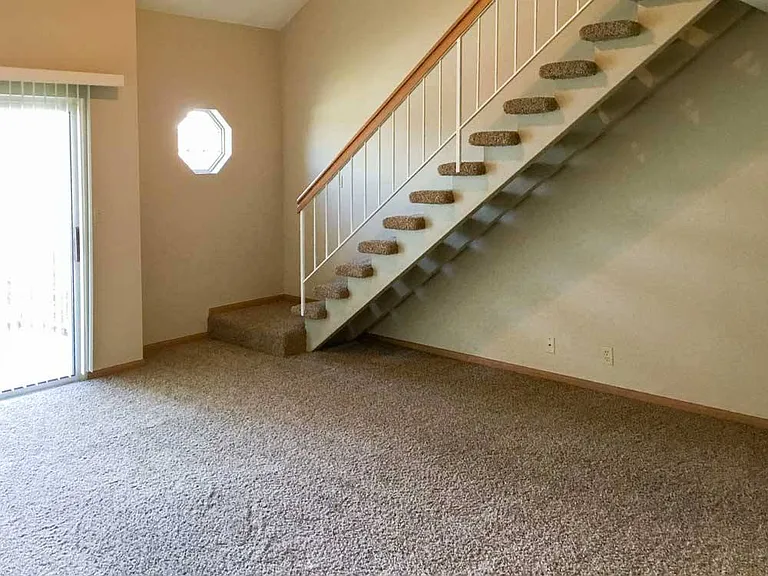 Make the most of your space with a unique two-level layout - this cozy living area features carpeted flooring and architectural charm.