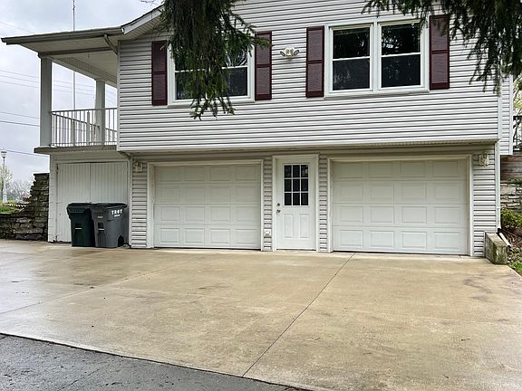 2 car garage with shed on left which sits below a bedroom and family room