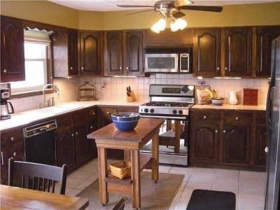Large kitchen with tons of cabinets, ceramic floor, counters and backsplash