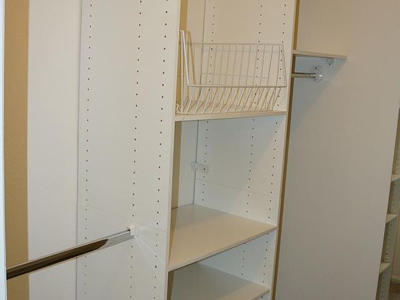 Master Bedroom Walk-in Closet with built-in shelving and drawers