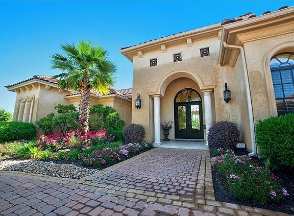 Circle paved driveway with beautiful landscaping and tropical Palm tree greet you as you enter the Cantera doors on this pristine Mediterraen Style 5,000 square foot home