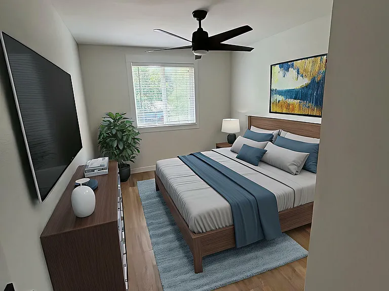Inviting bedroom with modern decor featuring a sleek ceiling fan, stylish artwork, and abundant natural light from a large window.