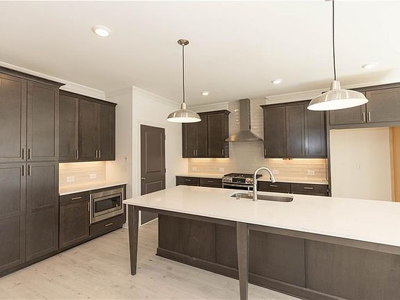 The large island offers plenty of counterspace Photos of a previously built home and Not of Actual