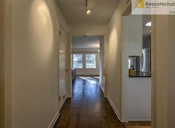 Entry hall with halogen lighting! Coat closet and kitchen to the right, door to basement to the left, and living room ahead