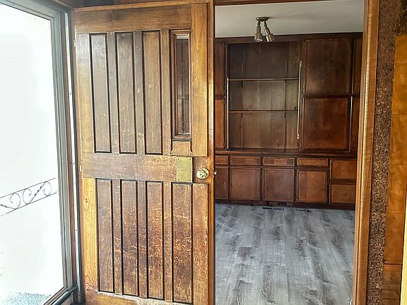 Front Door Entry: Step through the storybook front door and into the heart of the home. The warmth of wood, the craftsmanship of built-ins, and the new flooring create an inviting blend of vintage charm and modern comfort.