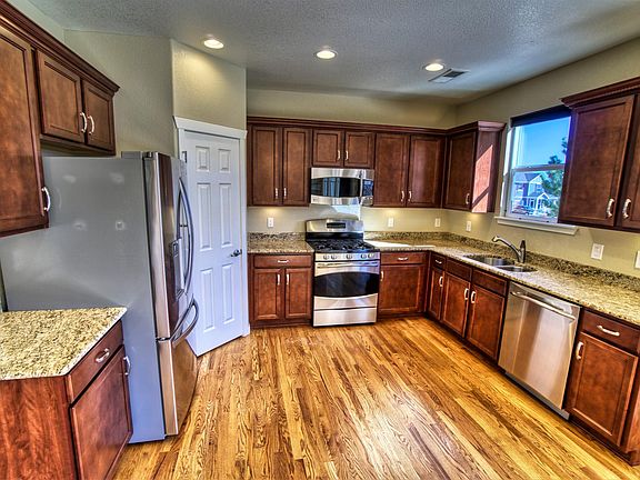 Main level - kitchen w/pantry, like-new stainless steel appliances, under-cabinet lighting, hardwood floors, and granite counter tops (14' x 11').