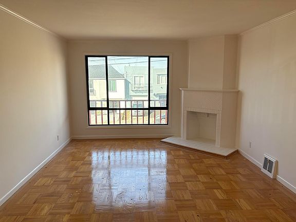 Living room with fireplace as decor. Newly painted and newly refinished hardwood floors.