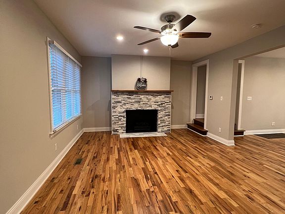 View of the Living Area with Hardwood Floors and Custom Fireplace Mantle and Hunter Ceiling Fans