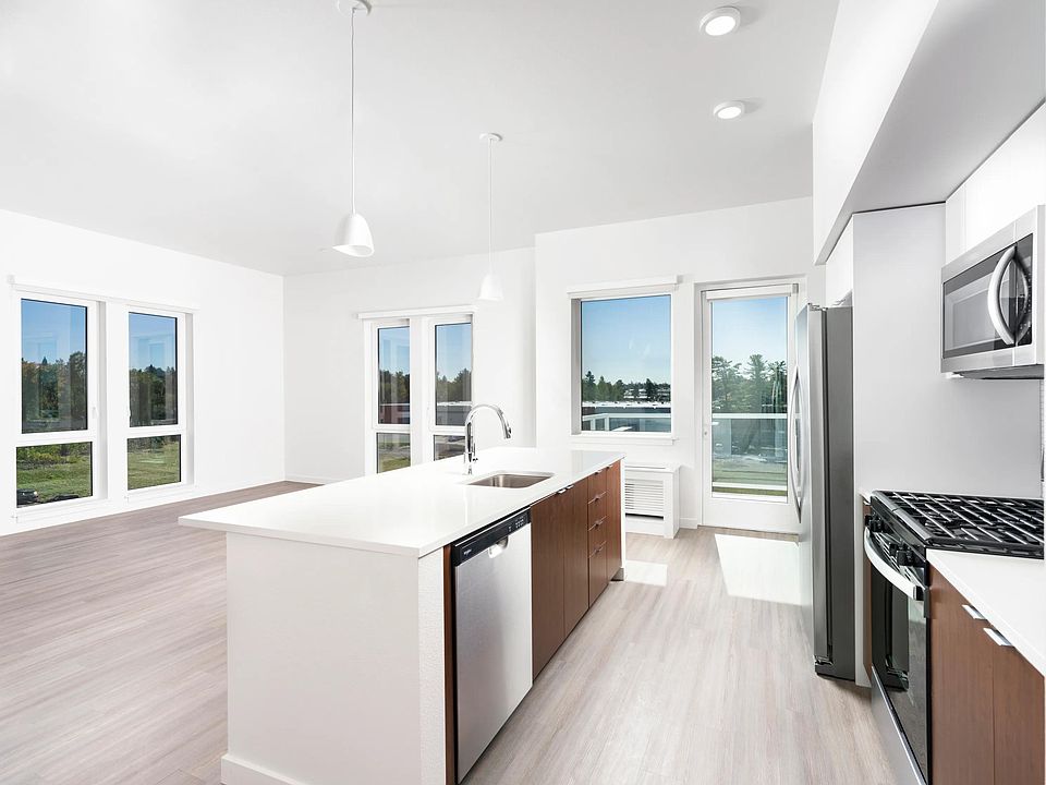 This open-concept apartment features a chef-ready kitchen with a gas range, sleek stainless steel appliances, and airy living spaces.