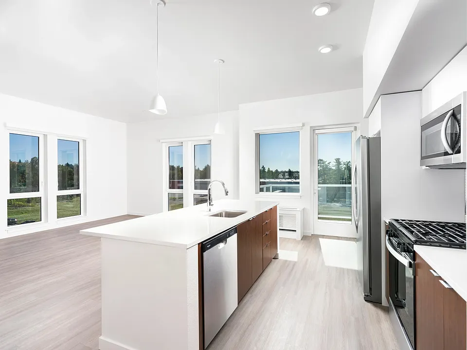 This open-concept apartment features a chef-ready kitchen with a gas range, sleek stainless steel appliances, and airy living spaces.